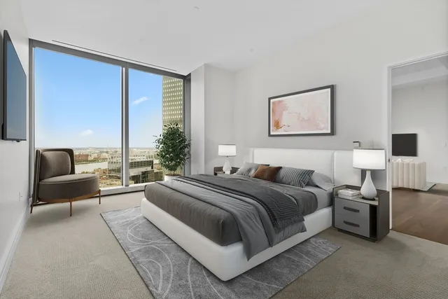 a spacious bedroom with a bed and glass window