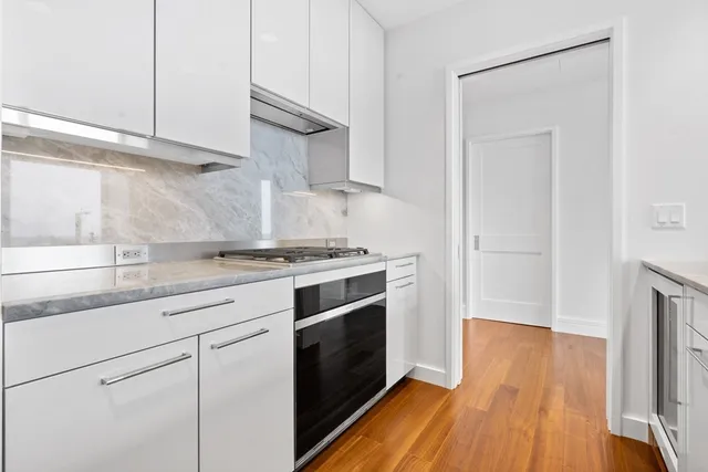 a kitchen with granite countertop wooden floors and white cabinets