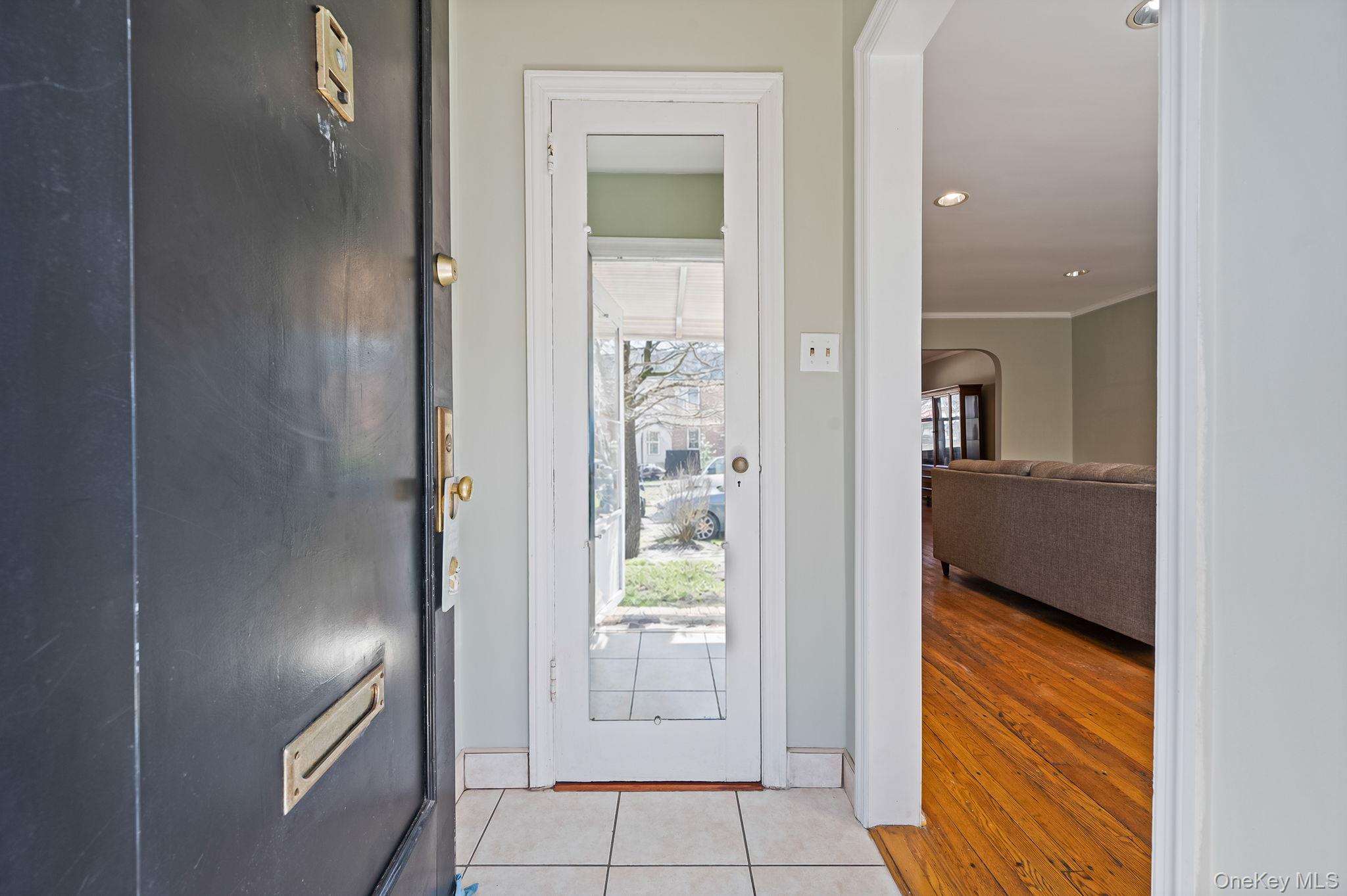 148-07 61st Road Queens, NY 11367 - Photo 4 of 21 Doorway featuring arched walkways, recessed lighting, and tile patterned floors with closet.