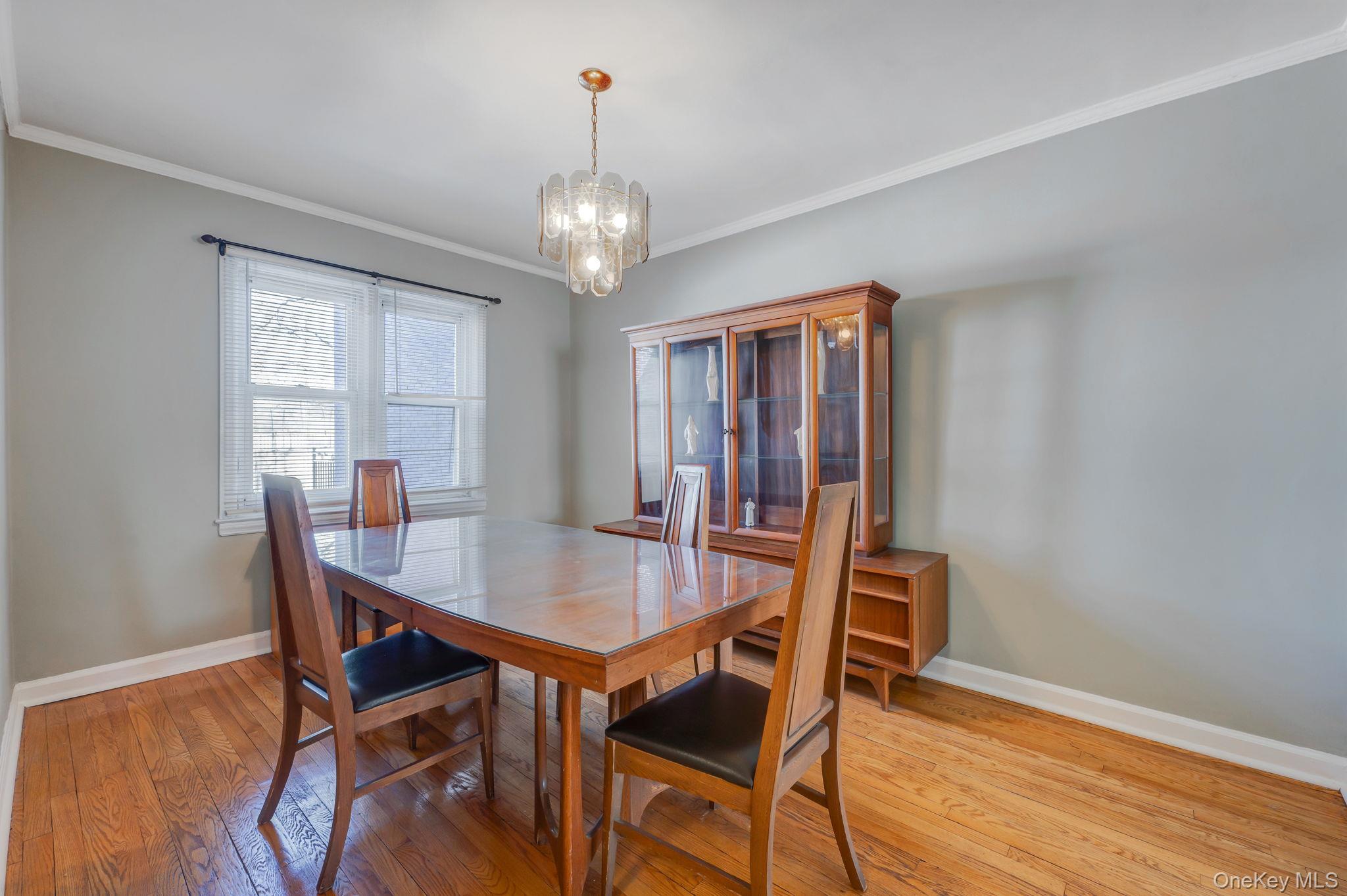 148-07 61st Road Queens, NY 11367 - Photo 7 of 21 Dining area featuring suspended lighting, molding, and light wood-style floors