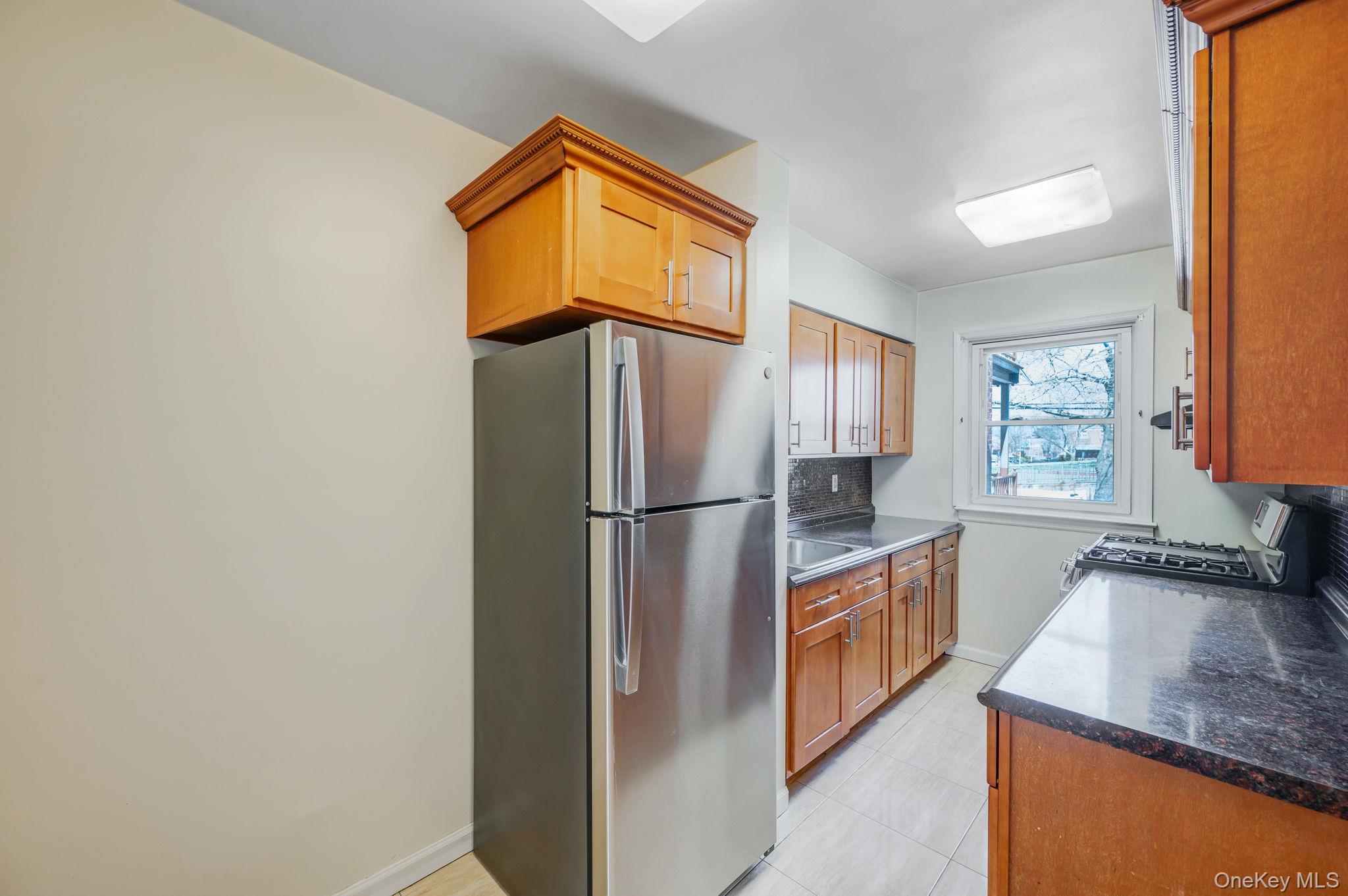 148-07 61st Road Queens, NY 11367 - Photo 9 of 21 Kitchen featuring stainless steel appliances and wood finish cabinetry