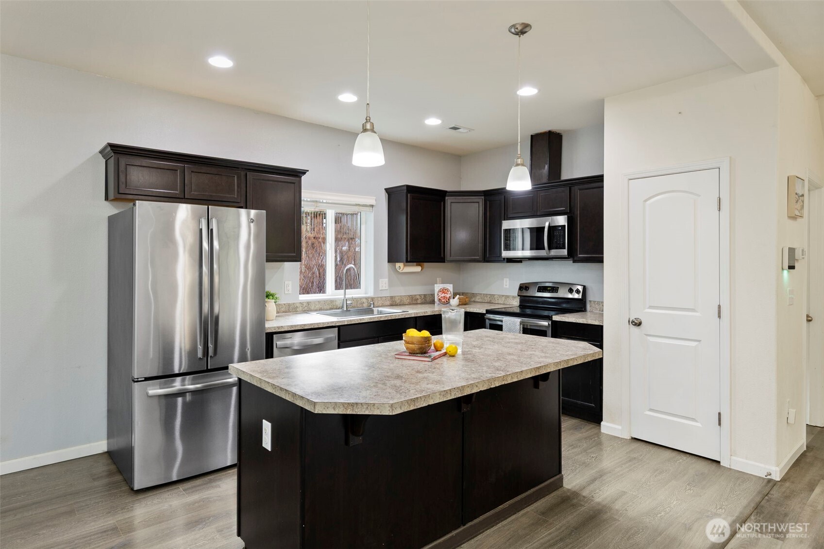 141 Southwest Marcia Way Port Orchard, WA 98366 - Photo 6 of 21 a kitchen with stainless steel appliances a refrigerator a sink a stove a microwave and island