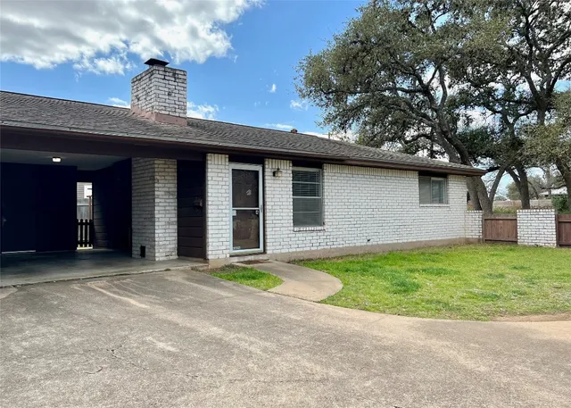 a backyard of a house with barbeque oven table and chairs