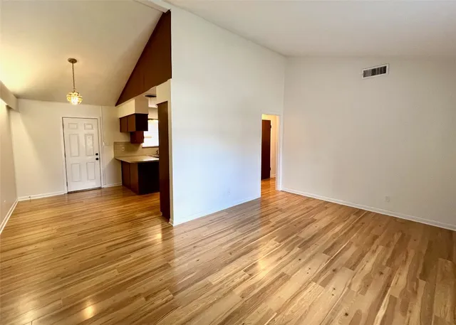 a view of empty room with wooden floor