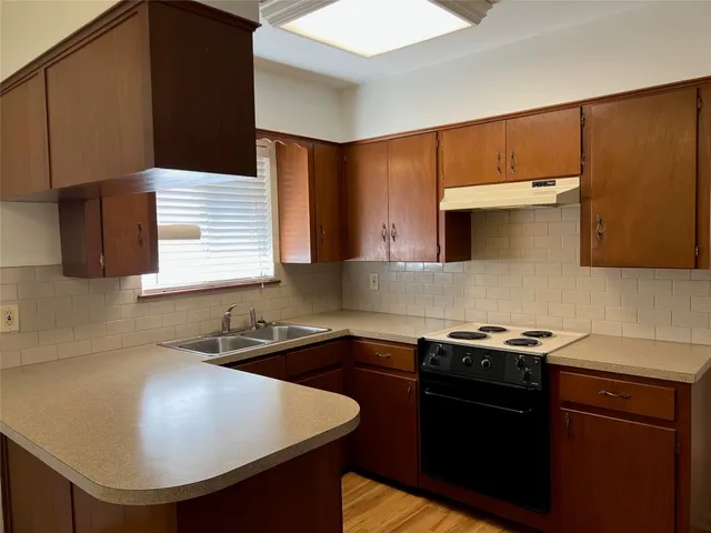 a kitchen with a sink a stove and a microwave