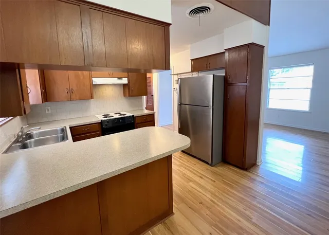 a kitchen with a refrigerator and a sink
