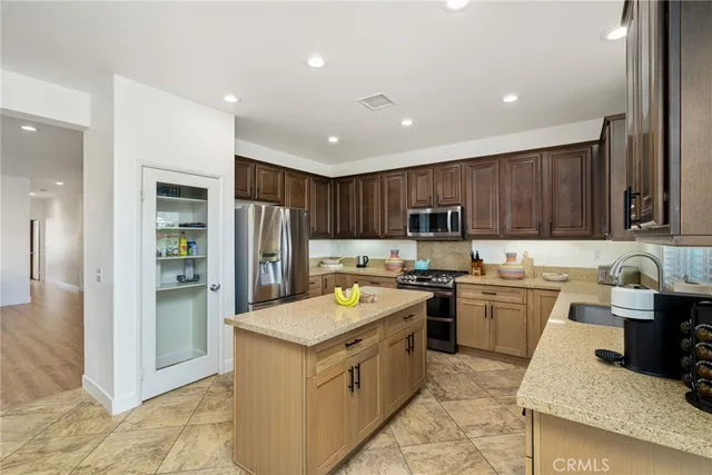 a kitchen with stainless steel appliances granite countertop a refrigerator stove and sink