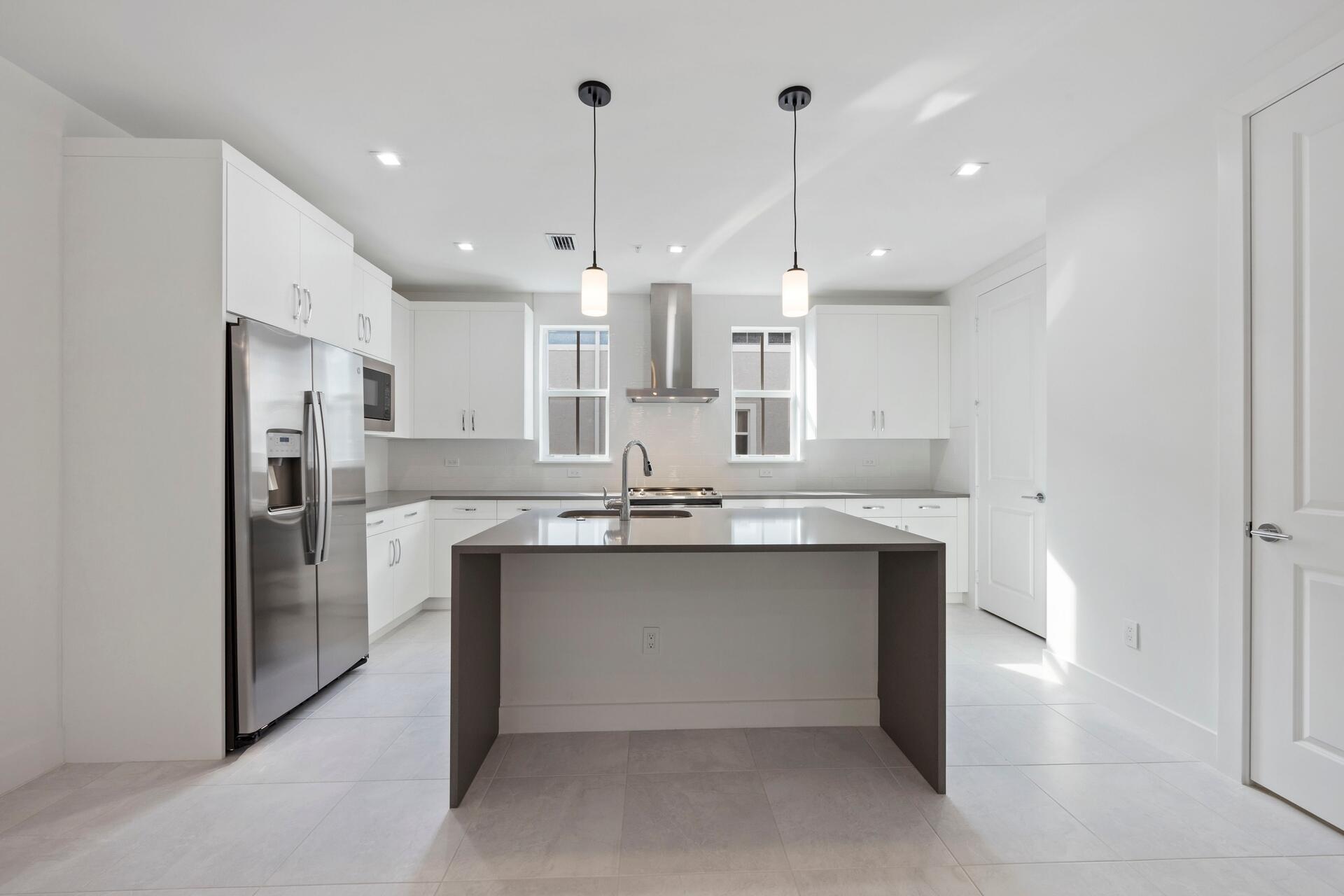 58 Atlantic Grove Way Delray Beach, FL 33444 - Photo 3 of 19 a kitchen with stainless steel appliances kitchen island a sink and a refrigerator