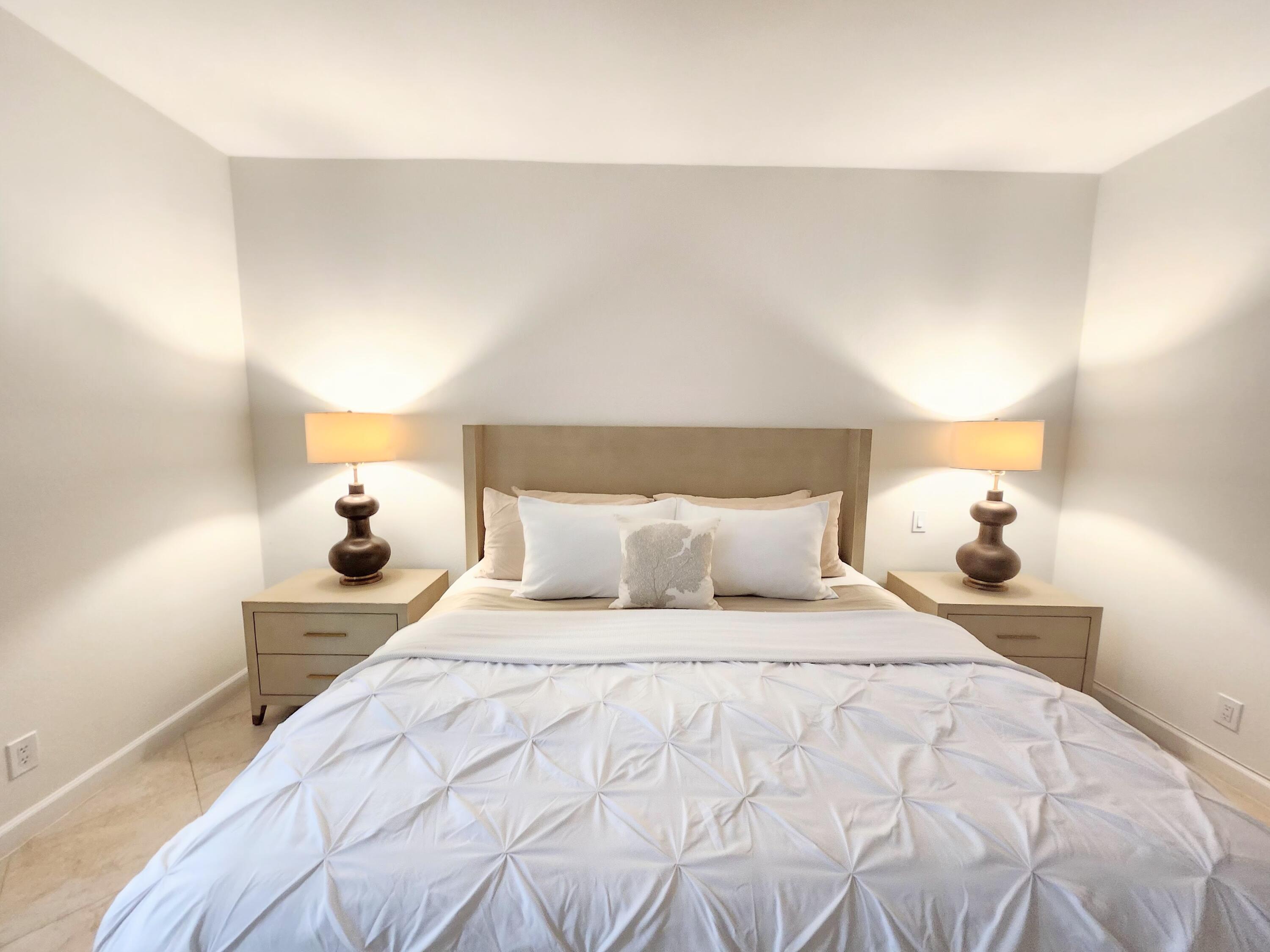 3567 Commodore Circle Delray Beach, FL 33483 - Photo 28 of 76 a bedroom with a bed and a lamp