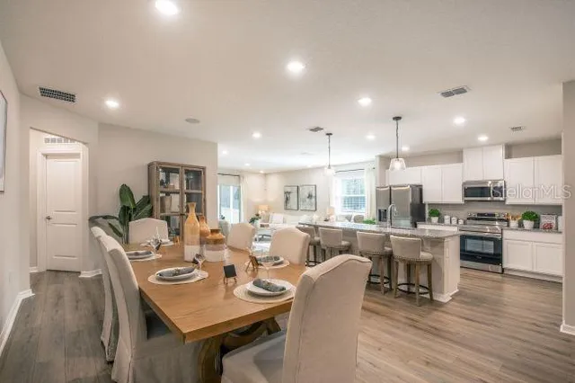 a living room with furniture a flat screen tv and kitchen view