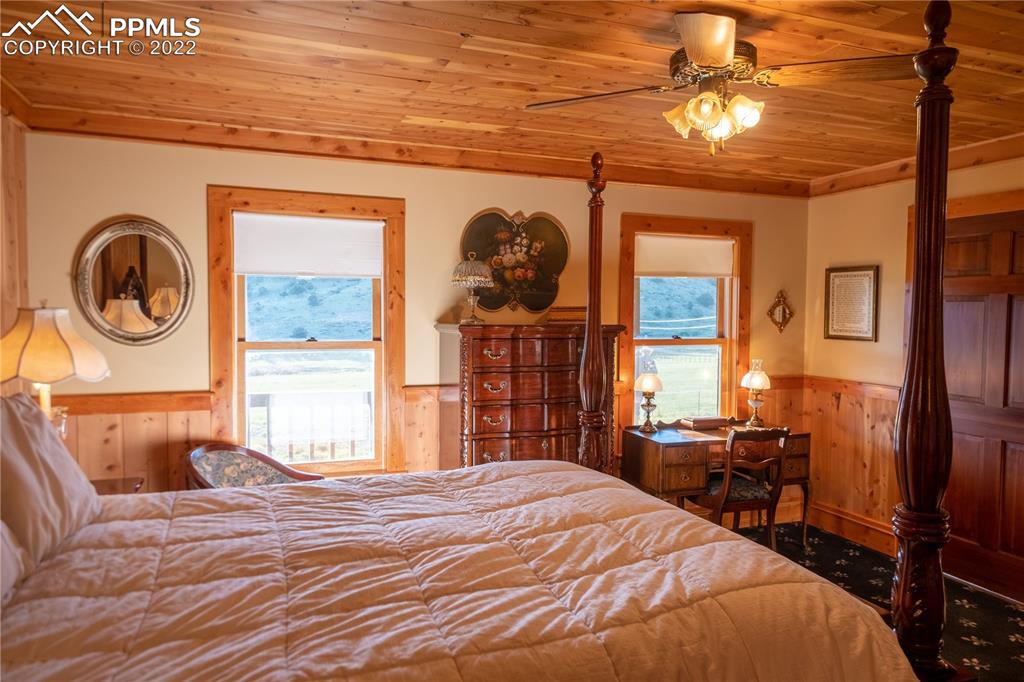 85 Excelsior Road Silver Cliff, CO 81252 - Photo 19 of 27 a bedroom with a bed and a chandelier