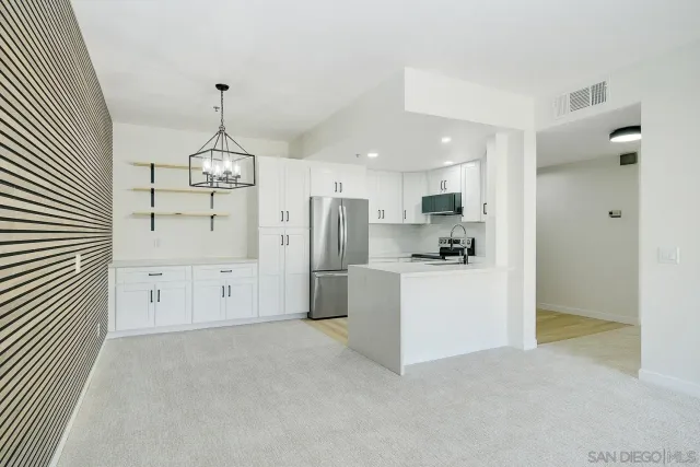 a view of a kitchen with refrigerator and white cabinets