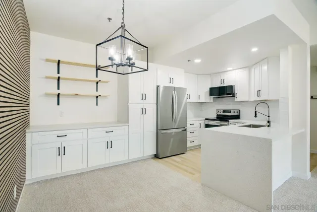 a kitchen with white cabinets and stainless steel appliances