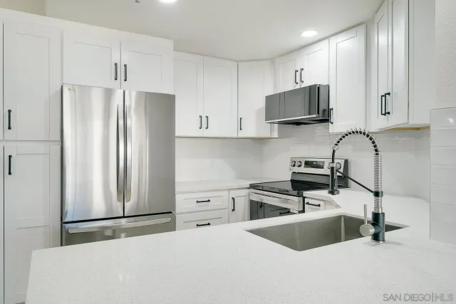 a kitchen with stainless steel appliances granite countertop a refrigerator sink and stove