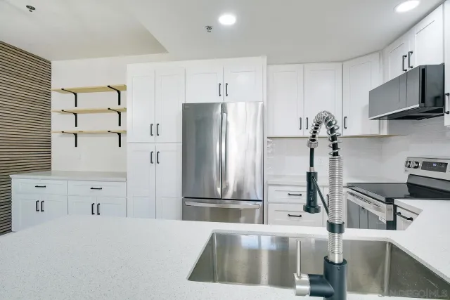 a kitchen with stainless steel appliances kitchen island granite countertop a refrigerator and a stove