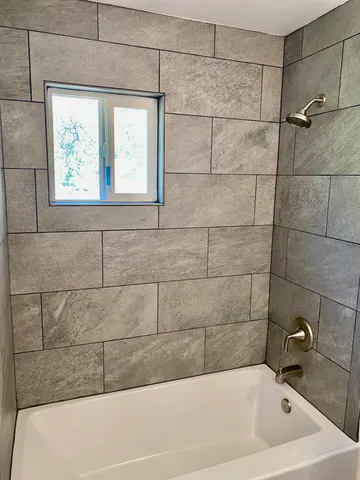 a bathroom with a bathtub and window