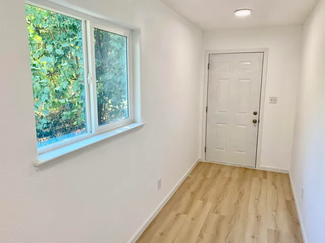 a view of a room with wooden floor and natural light