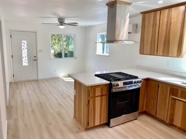 a kitchen with a stove and a wooden floors