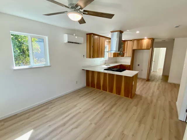 a kitchen with stainless steel appliances granite countertop a sink a stove a refrigerator cabinets and wooden floor