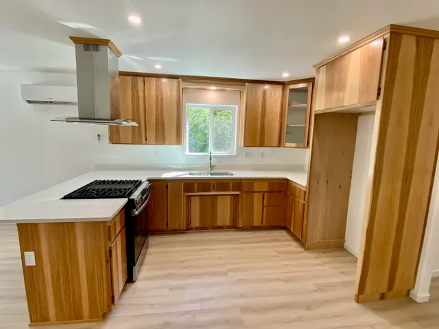 a kitchen with stainless steel appliances a stove a refrigerator and a window