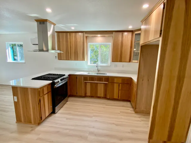 a kitchen with stainless steel appliances granite countertop a stove a sink and a refrigerator