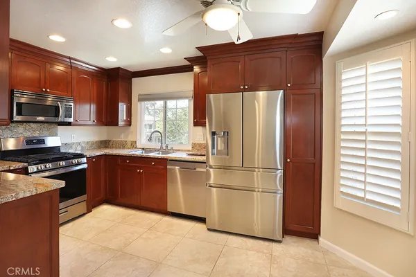 a kitchen with stainless steel appliances granite countertop a refrigerator stove top oven a sink and dishwasher
