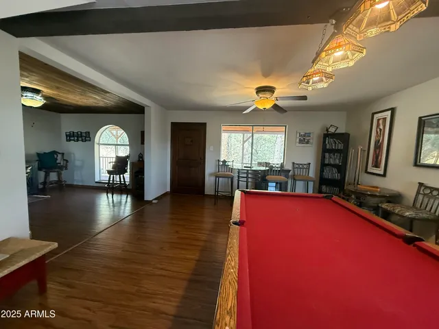 a bedroom with a bed a painting on the wall and a large window