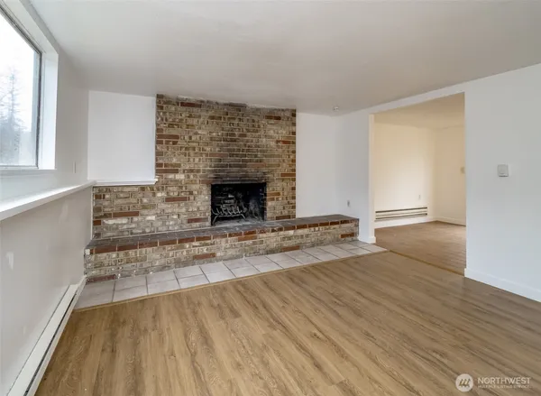 wooden floor fireplace and windows in an empty room