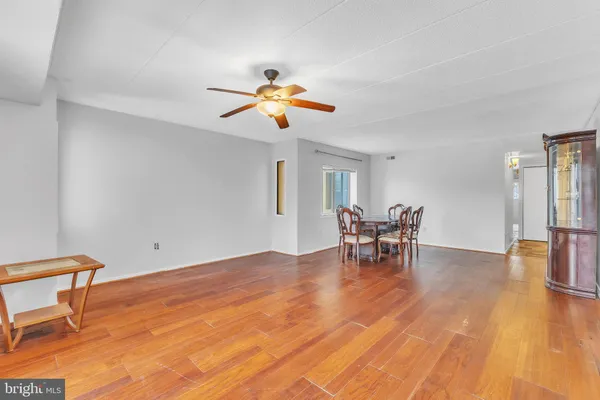 a view of a livingroom with wooden floor and a ceiling fan