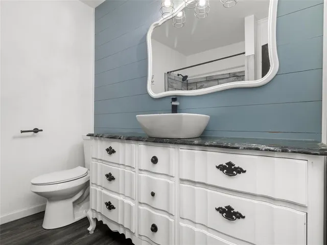 a bathroom with a sink a toilet and a mirror