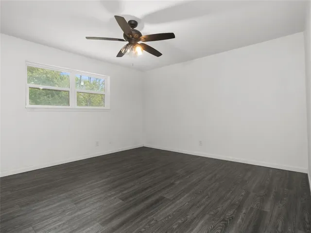 a view of a big room with wooden floor and windows