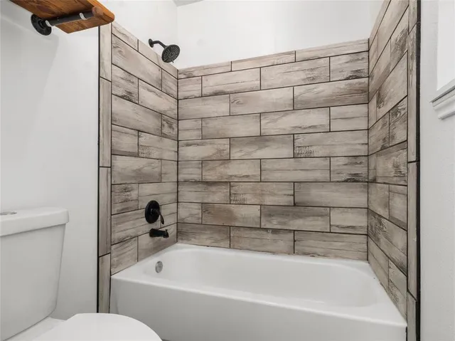 a bathroom with a bathtub and a toilet