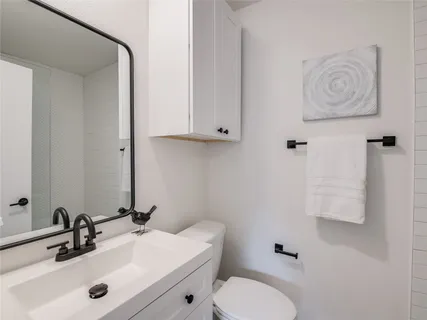 a bathroom with a toilet sink and mirror