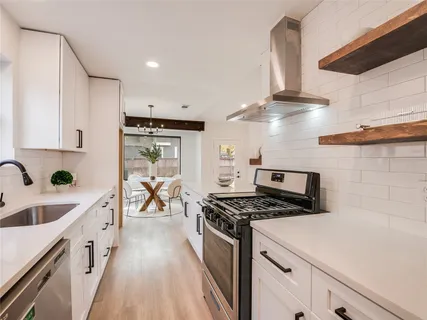 a kitchen with stainless steel appliances a sink a stove and cabinets