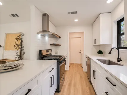 a kitchen with stainless steel appliances a sink stove and refrigerator