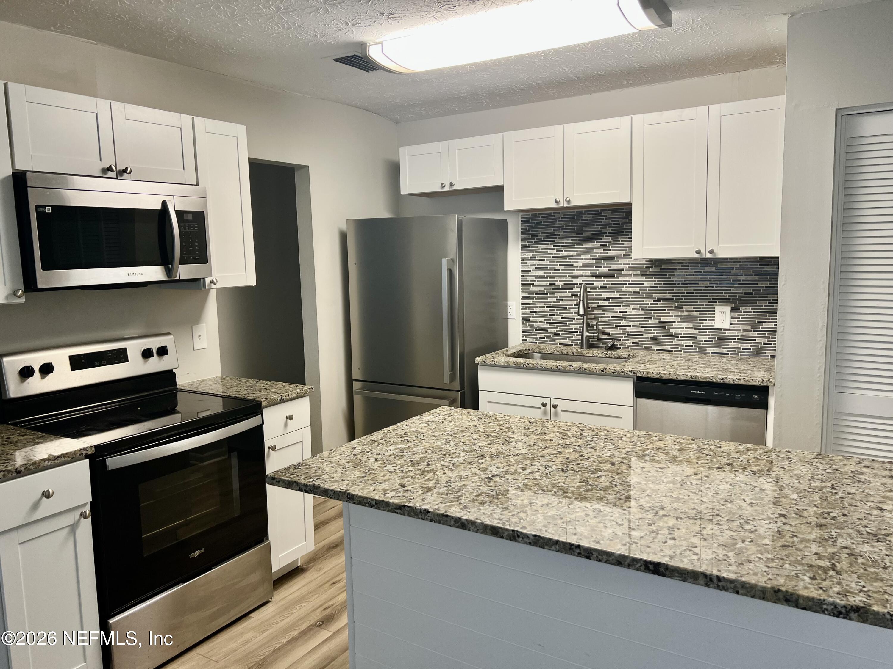 10964 Bacall Road West Jacksonville, FL 32218 - Photo 9 of 19 a kitchen with kitchen island a sink appliances and cabinets