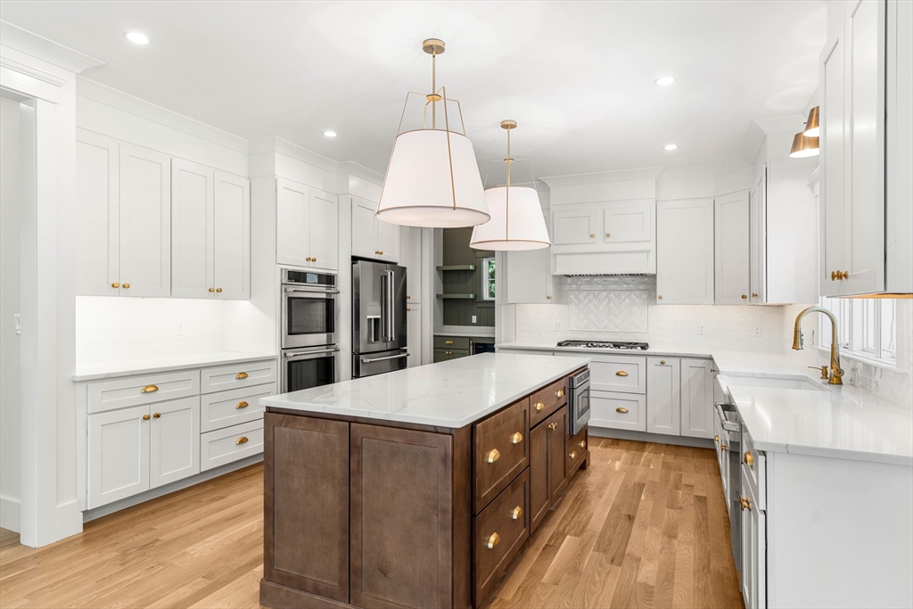 1 Elm Street Middleton, MA 01949 - Photo 8 of 42 a kitchen with granite countertop a sink stove a refrigerator and white cabinets with wooden floor