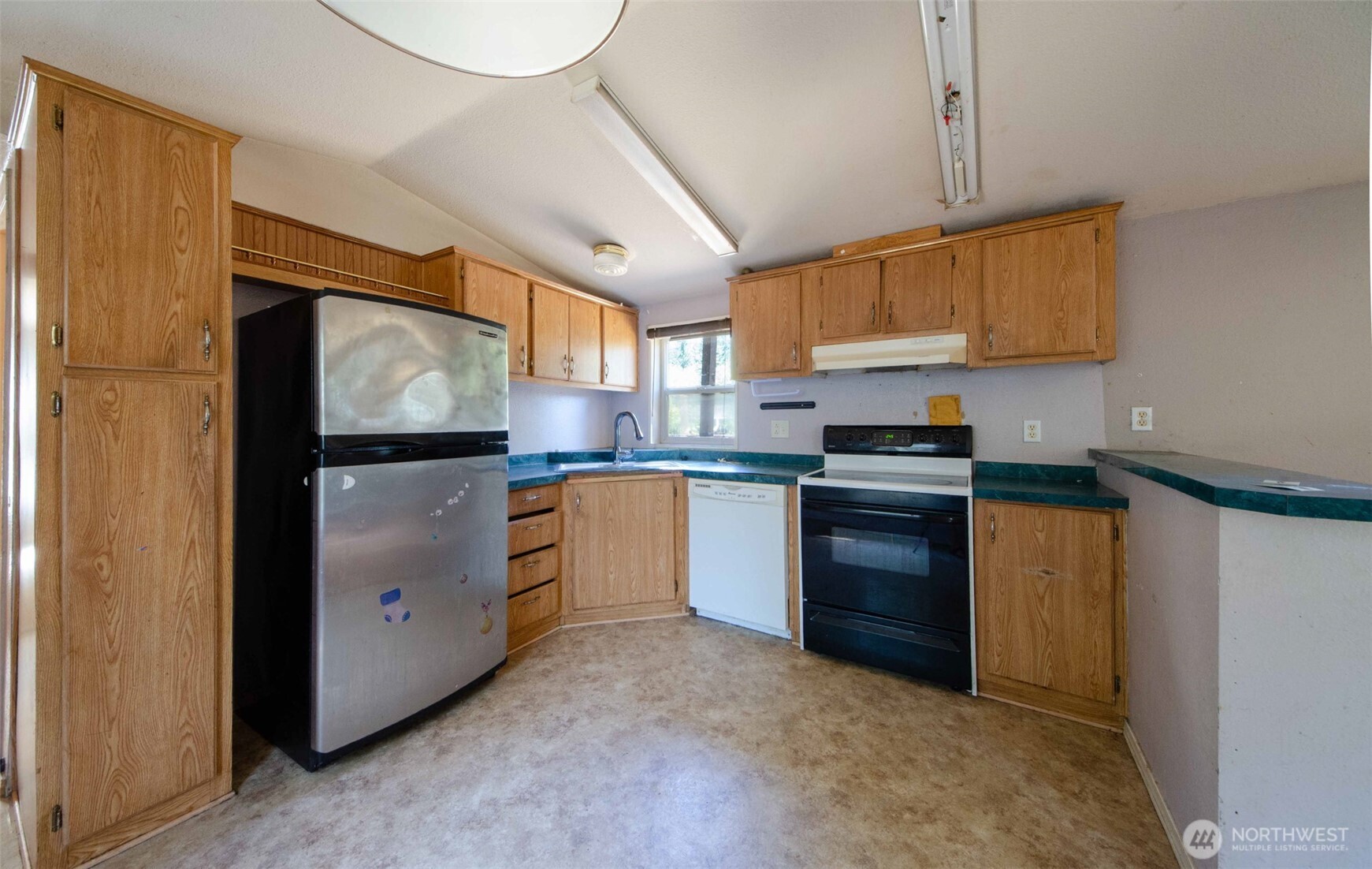 1487 Centralia Alpha Road Chehalis, WA 98532 - Photo 21 of 36 a kitchen with granite countertop a refrigerator a sink a stove and white cabinets