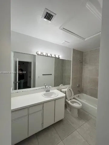 a bathroom with a double vanity sink toilet mirror and bathtub