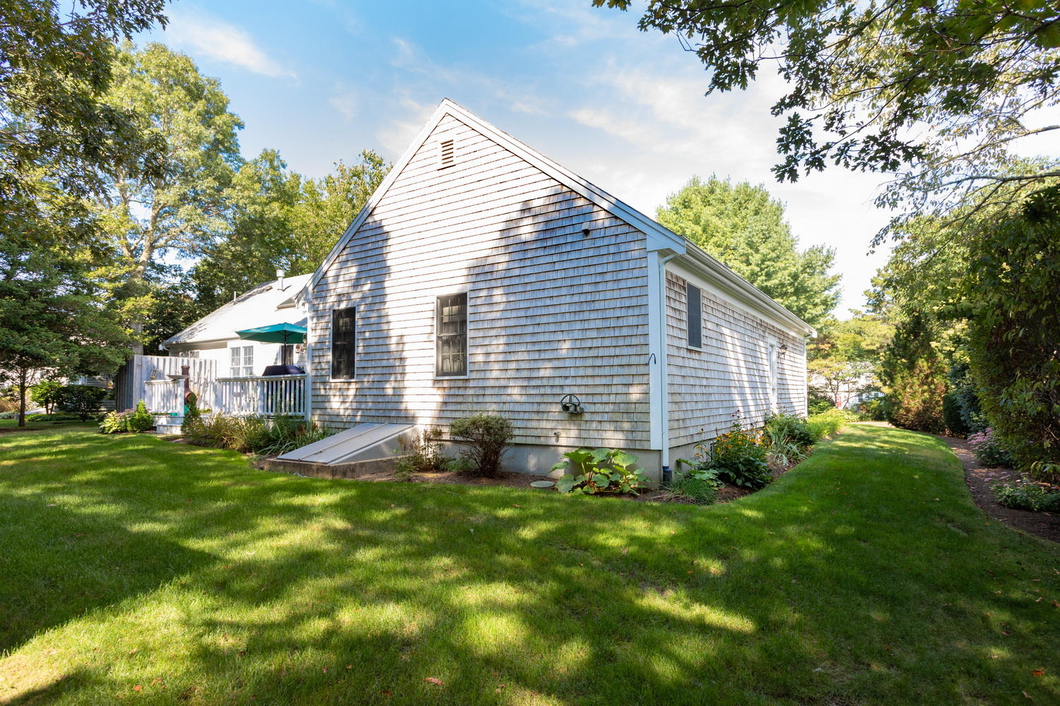 178 Winding Cove Road Marstons Mills, MA 02648 - Photo 3 of 17 a view of a backyard with plants and large tree