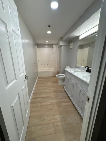 a bathroom with a sink a toilet and a large mirror