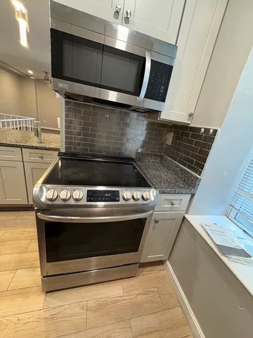 a stove top oven sitting inside of a kitchen