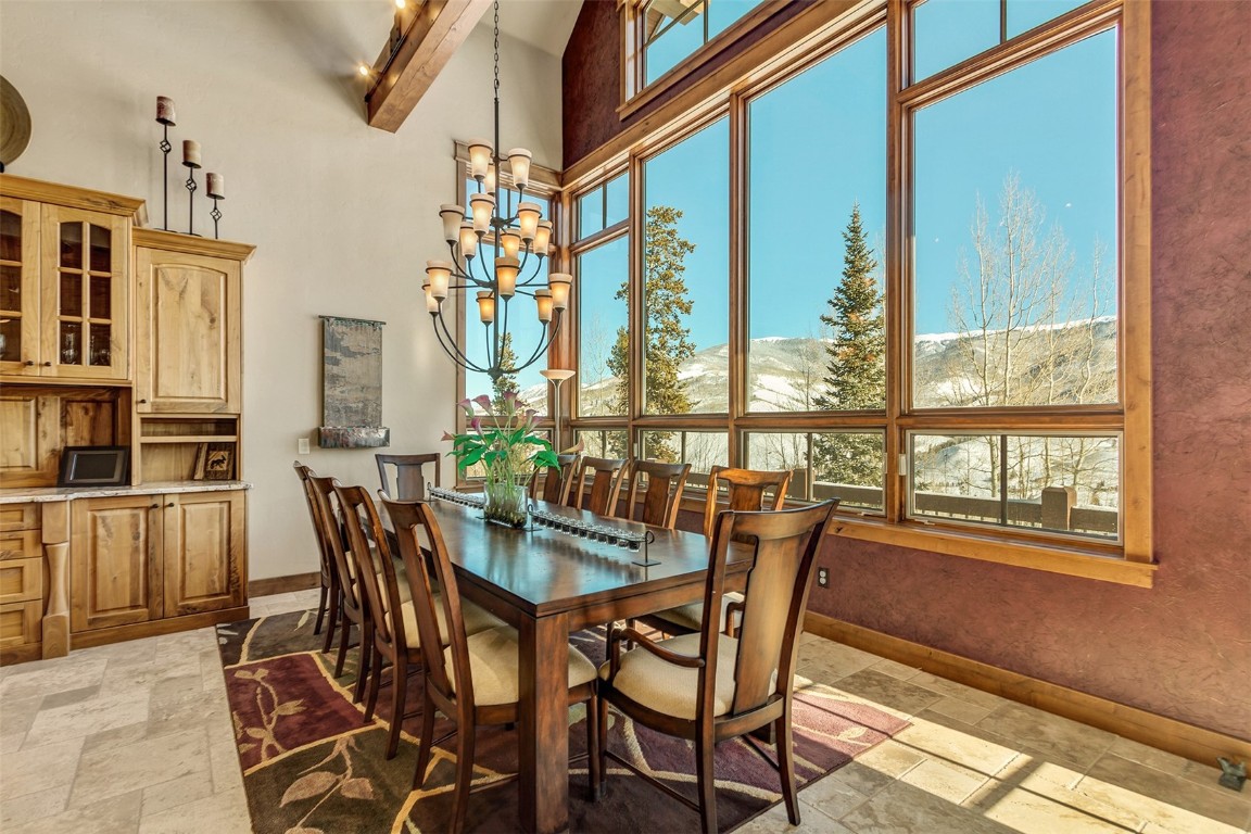 1680 Golden Eagle Road Silverthorne, CO 80498 - Photo 13 of 40 a view of a dining room with furniture large windows and wooden floor