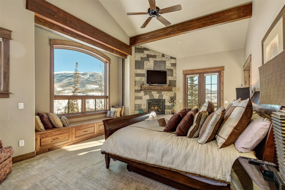 1680 Golden Eagle Road Silverthorne, CO 80498 - Photo 15 of 40 a spacious bedroom with a bed a flat screen tv and windows