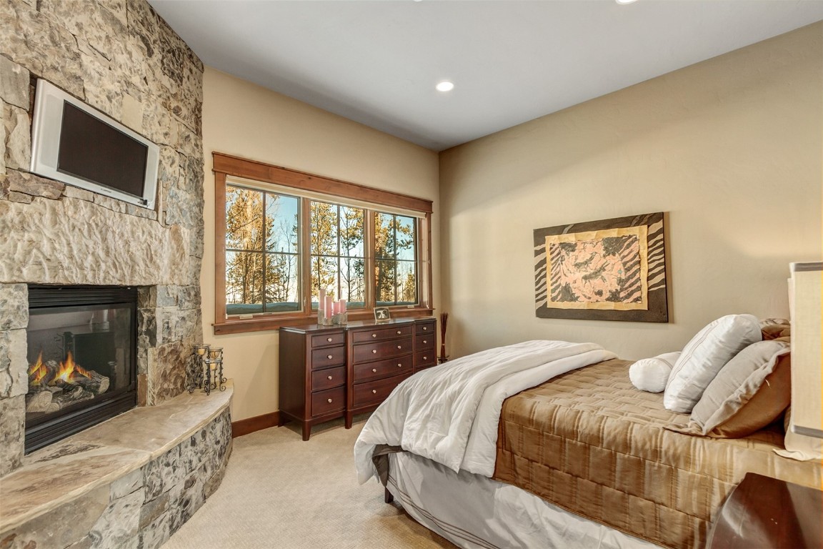 1680 Golden Eagle Road Silverthorne, CO 80498 - Photo 23 of 40 a bedroom with a bed and a fireplace