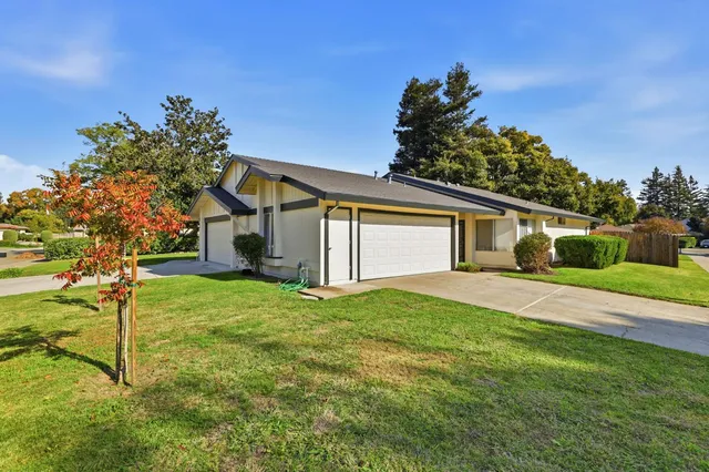 a front view of a house with a yard and trees