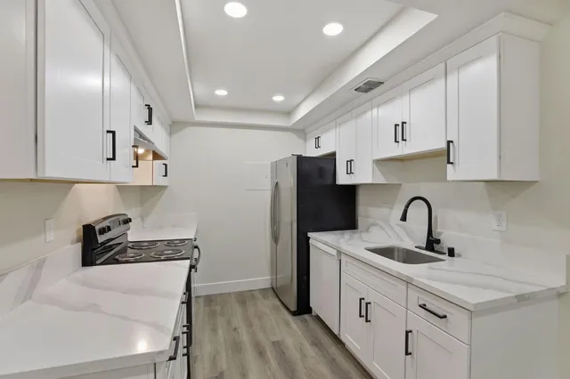 a kitchen that has a lot of cabinets and wooden floor