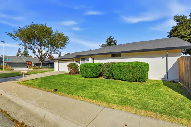 a front view of a house with a garden and garage