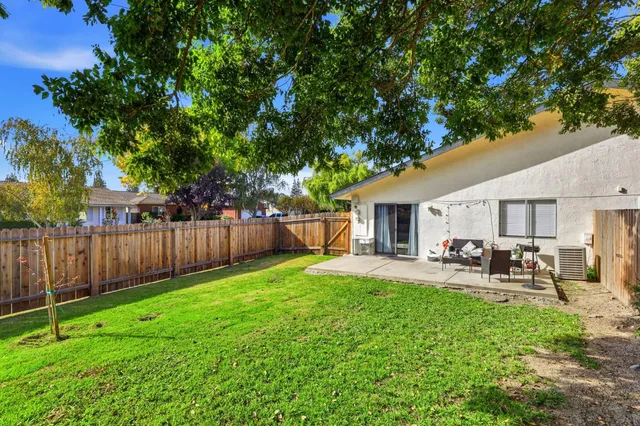 a view of a yard with a house and a large tree