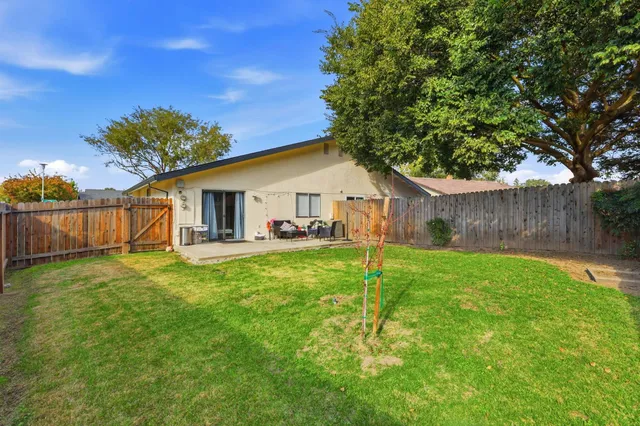 a view of a backyard with table and chairs and wooden fence